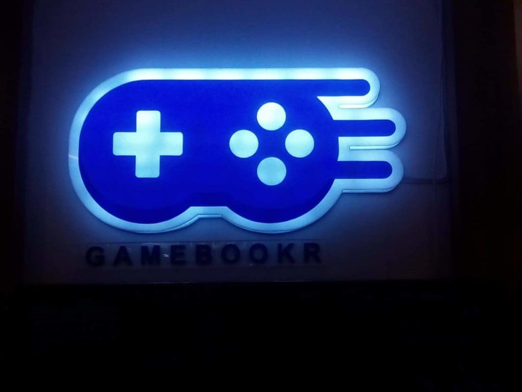 LED signage for GAMEBOOKR game store in Makati, blue controller icon, black letters on dark background by M&G Global Ads.